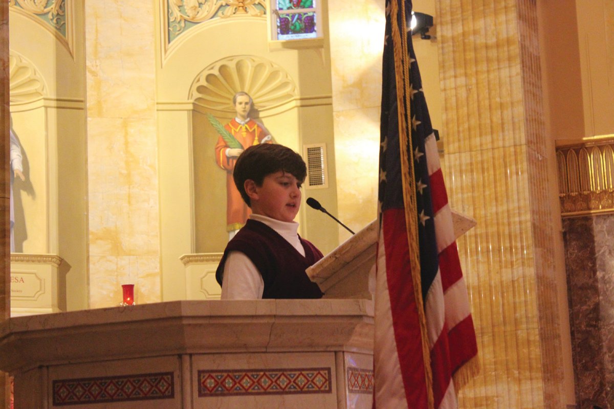 PATRIOTIC PRAYERS: St. Rocco School held its Veterans Day Prayer Service Wednesday, Nov. 9 at St. Rocco Church, 931 Atwood Ave., Johnston. Students from St. Rocco School read poems that they wrote, carried photos of loved ones, sang patriotic songs and prayed for all veterans.  Also, the school held a “Dress Down Day” for "Operation Christmas Stocking" where students dressed in red, white and blue, along with donating a dollar for the cause. Proceeds will go toward filling stockings for soldiers in the 43rd MP Brigade.